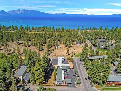 an aerial view of a resort with the lake and mountains at Secrets Inn Lake Tahoe in South Lake Tahoe