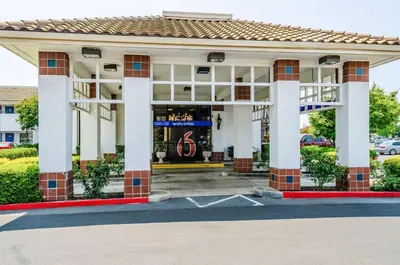 a building with white columns in a parking lot at Motel 6 Oakdale, Ca in Oakdale
