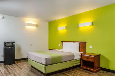 a room with a bed with a green wall at Motel 6 Oakdale, Ca in Oakdale