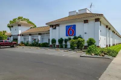 a front view of a hotel with a parking lot at Motel 6 Oakdale, Ca in Oakdale