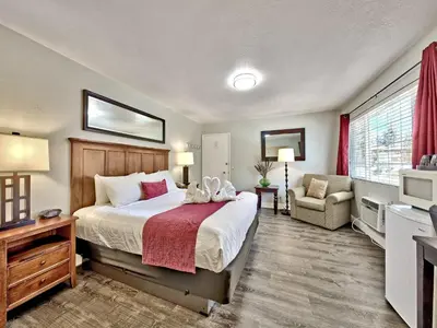 a bedroom with a bed and a couch and a television at Heavenly Inn Lake Tahoe in South Lake Tahoe