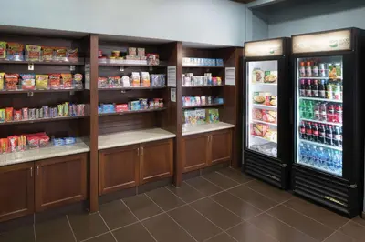 a grocery store aisle with two refrigerators and food at Homewood Suites by Hilton Fresno Airport/Clovis in Clovis