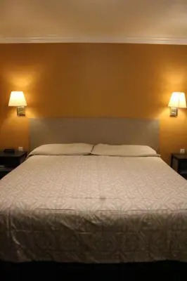 a bedroom with a large bed with two pillows at Timberline Motel in Lone Pine