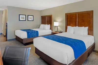 a hotel room with two beds and a chair at Comfort Inn & Suites Rocklin - Roseville in Rocklin