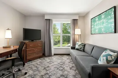 a living room with a couch and a desk and a tv at Homewood Suites by Hilton Sacramento/Roseville in Roseville