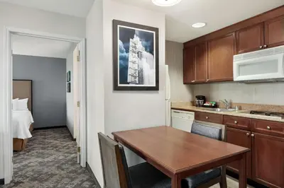 a kitchen with a wooden table in a room at Homewood Suites by Hilton Sacramento/Roseville in Roseville
