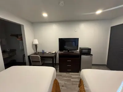 a hotel room with two beds and a flat screen tv at Travelodge by Wyndham Sacramento / Rancho Cordova in Sacramento