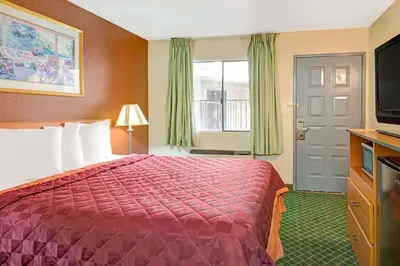 a hotel room with a bed and a television at Travelodge by Wyndham Sacramento / Rancho Cordova in Sacramento