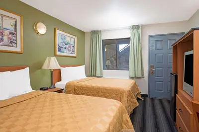 a hotel room with two beds and a television at Travelodge by Wyndham Sacramento / Rancho Cordova in Sacramento