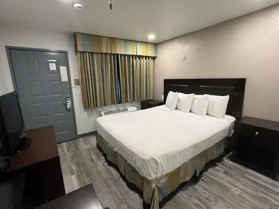 a hotel room with a large bed and a door at Travelodge by Wyndham Sacramento / Rancho Cordova in Sacramento