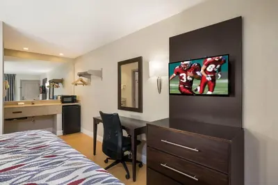 a hotel room with a desk and a television on the wall at Red Roof Inn Stockton in Stockton