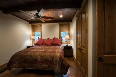 a bedroom with a bed with red pillows and a ceiling at 1R Rustic Retreat in Wawona
