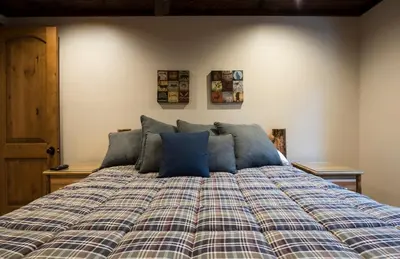 a large bed with blue pillows in a bedroom at 1R Rustic Retreat in Wawona