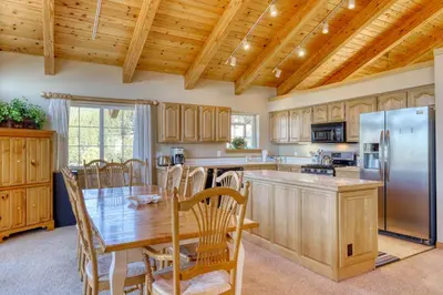 a kitchen with a table and a stainless steel refrigerator at Altdorf Vista in Tyrolian Village