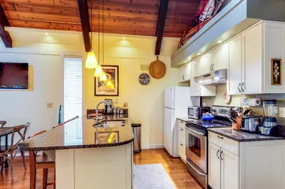 a kitchen with white cabinets and a counter top at Casa del Lago in Tyrolian Village