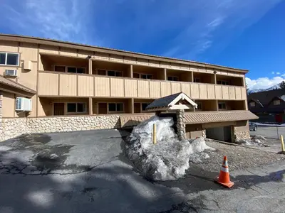 a building with a snow pile in front of it at SureStay Plus Hotel by Best Western Mammoth Lakes in Mammoth Lakes