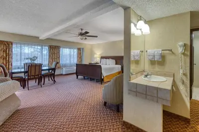 a hotel room with a bed and a bathroom at SureStay Plus Hotel by Best Western Reno Airport in Reno