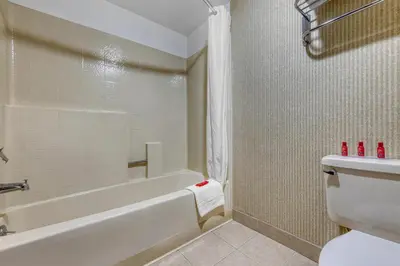a bathroom with a white tub and a toilet at SureStay Plus Hotel by Best Western Reno Airport in Reno