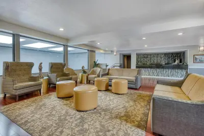 a lobby with couches and chairs and a bar at SureStay Plus Hotel by Best Western Reno Airport in Reno