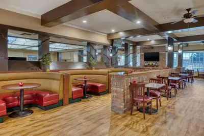 a restaurant with tables and chairs and a bar at SureStay Plus Hotel by Best Western Reno Airport in Reno