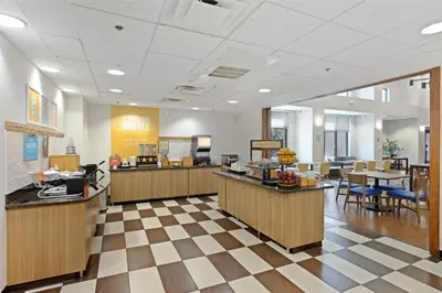 a lobby of a hospital with tables and chairs at Hampton Inn & Suites Madera in Madera