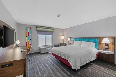 a hotel room with a bed and a flat screen tv at Hampton Inn & Suites Madera in Madera