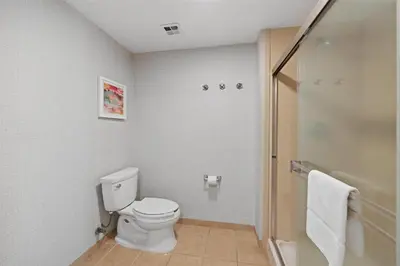 a white bathroom with a toilet and a shower at Hampton Inn & Suites Madera in Madera