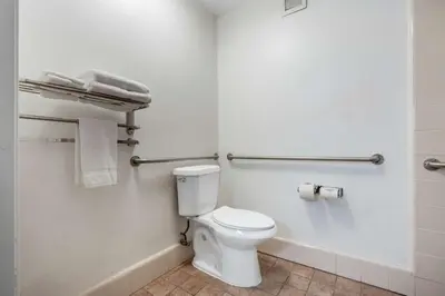 a bathroom with a white toilet and towels at Best Western Colonial Inn in Selma