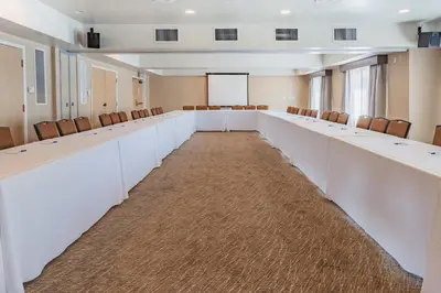 a large room with white desks and chairs at Holiday Inn Express Hotel & Suites San Jose-Morgan Hill by IHG in Morgan Hill