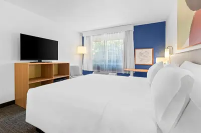 a hotel room with a large white bed and a tv at Spark by Hilton Modesto in Modesto