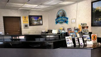a restaurant with a counter with signs on the wall at Yosemite Sierra Inn in Oakhurst