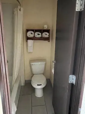 a bathroom with a toilet and two rolls of toilet paper at Yosemite Sierra Inn in Oakhurst