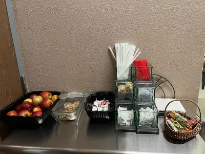 a table with a vase of apples and baskets of food at Yosemite Sierra Inn in Oakhurst