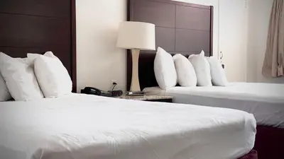 a hotel room with two beds with white pillows at The Yosemite Inn in Mariposa