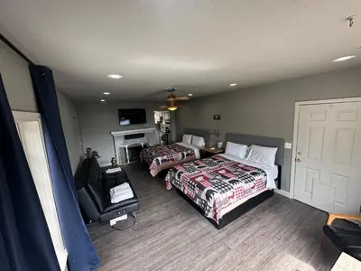 a hotel room with two beds and a fireplace at Mountain Trail Lodge and Vacation Rentals in Oakhurst