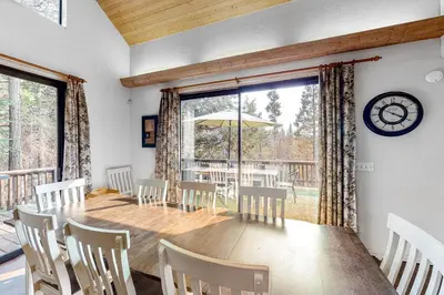 a dining room with a table and chairs and a clock at Forest Falls in Shaver Lake