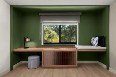 a green room with a window and a wooden desk at The Inelle, Oakhurst Yosemite, a Tribute Portfolio Hotel in Oakhurst