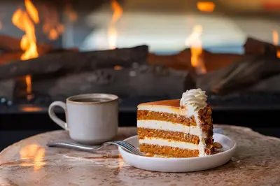 a piece of cake on a plate next to a cup of coffee at The Inelle, Oakhurst Yosemite, a Tribute Portfolio Hotel in Oakhurst