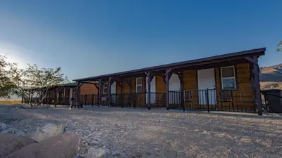 a log cabin with a fence around it at Panamint Springs Motel & Tents in Panamint Springs