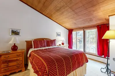 a bedroom with a bed with a red comforter at Donner Lake Retreat in Donner Pines Tract