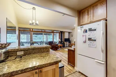 a kitchen with a white refrigerator and a living room at Donner Lake Retreat in Donner Pines Tract