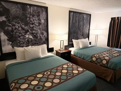 a hotel room with two beds and a painting on the wall at Super 8 by Wyndham Selma/Fresno Area in Selma