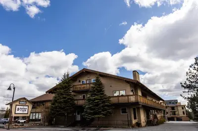 a large building with trees in front of it at The Mammoth Creek Inn in Mammoth Lakes