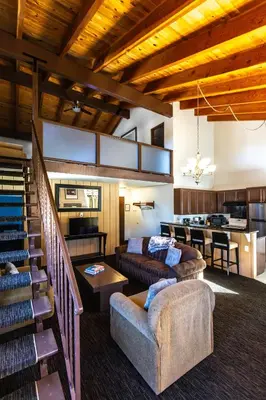 a living room with two couches and a kitchen at The Mammoth Creek Inn in Mammoth Lakes