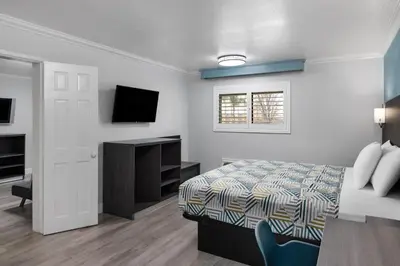a bedroom with a bed and a desk and a television at Red Lion Inn & Suites Lemoore in Lemoore