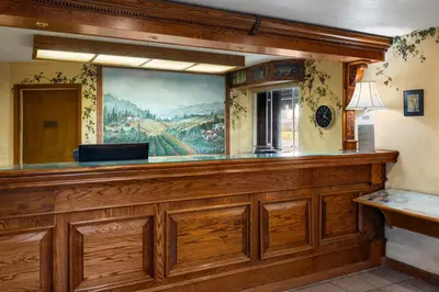 a bar in a restaurant with a painting on the wall at Red Lion Inn & Suites Lemoore in Lemoore
