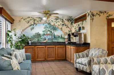 a living room with a kitchen with a painting on the wall at Red Lion Inn & Suites Lemoore in Lemoore