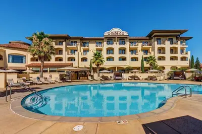 a hotel with a large swimming pool in front of a building at The Murieta Inn and Spa in Rancho Murieta