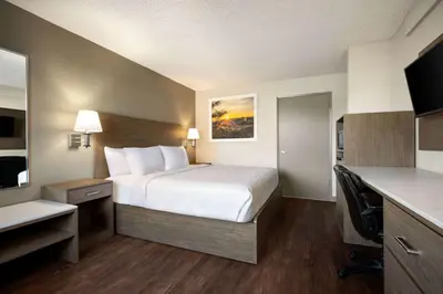 a hotel room with a bed and a desk at Days Inn by Wyndham Fresno South in Fresno