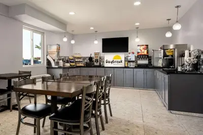 a restaurant with a table and chairs and a counter at Days Inn by Wyndham Fresno South in Fresno